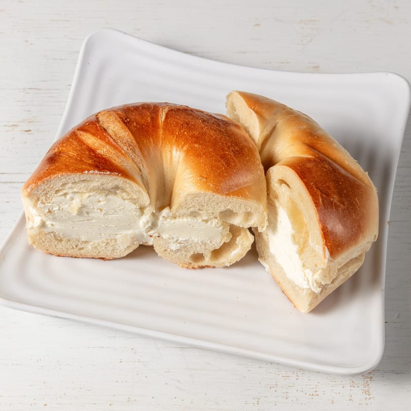 Freshly baked bagel from Pierce Street Bagel Cafe, sliced and filled with a generous layer of cream cheese.